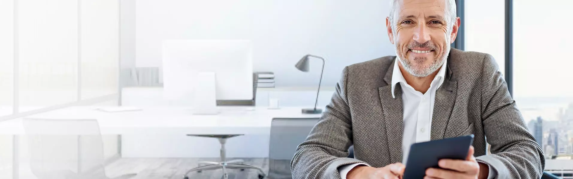 Lächelnder Mann in Büro mit Smartphone in der Hand