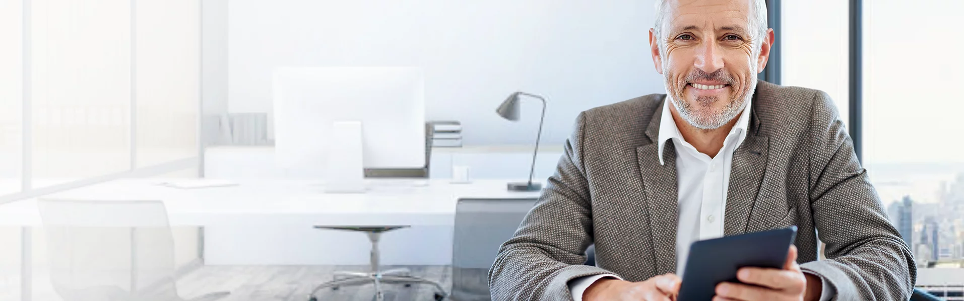 Lächelnder Mann in Büro mit Smartphone in der Hand