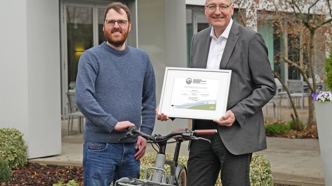 Dr. Jörg Teupen (re.) präsentiert das Zertifikat, mit dem Jan Voß (li.) das besondere Engagement der Stadtwerke Kiel für nachhaltige Mobilität und die gezielte Förderung von fahrradfreundlichen Arbeitsbedingungen würdigt.