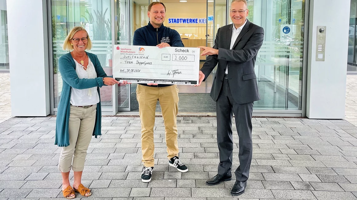 Aus 60 Millionen Schritten wird eine 2.000 Euro Spende: Technik- und Personalvorstand, Dr. Jörg Teupen (re.), übergibt gemeinsam mit Ideengeberin Gitte Küster den symbolischen Spendenscheck an Mirko Westphal vom Team DoppelPASS. Aus 60 Millionen Schritten wird eine 2.000 Euro Spende: Technik- und Personalvorstand, Dr. Jörg Teupen (re.), übergibt gemeinsam mit Ideengeberin Gitte Küster den symbolischen Spendenscheck an Mirko Westphal vom Team DoppelPASS.