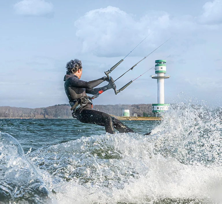 Kitesurfer auf dem Wasser vor dem Leuchtturm Friedrichsort
