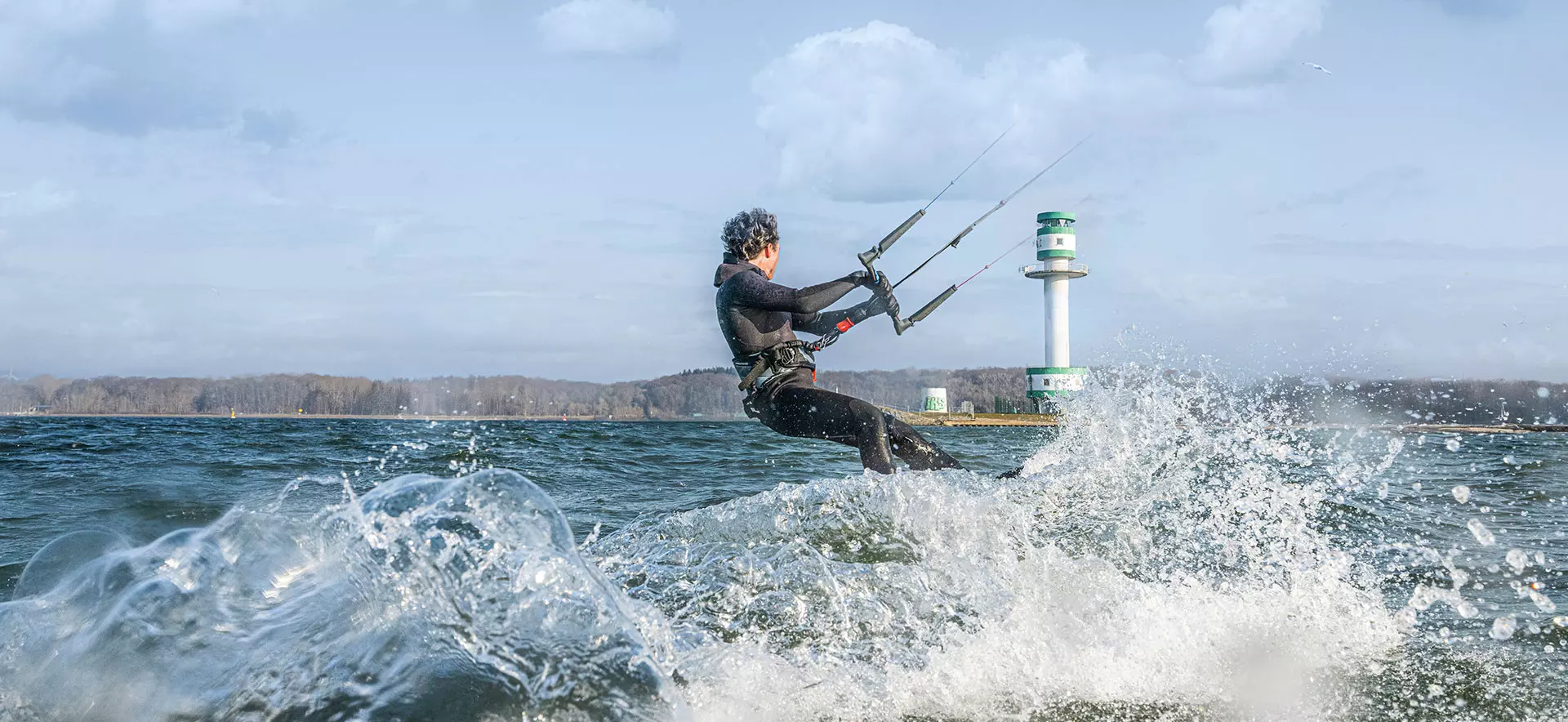 Kitesurfer auf dem Wasser vor dem Leuchtturm Friedrichsort