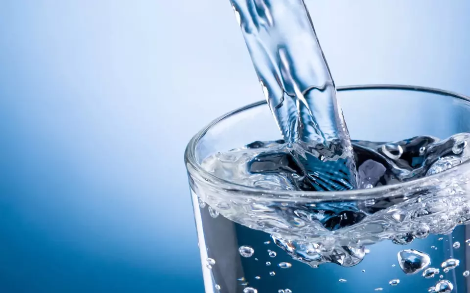 klares Wasser fließt in ein Glas