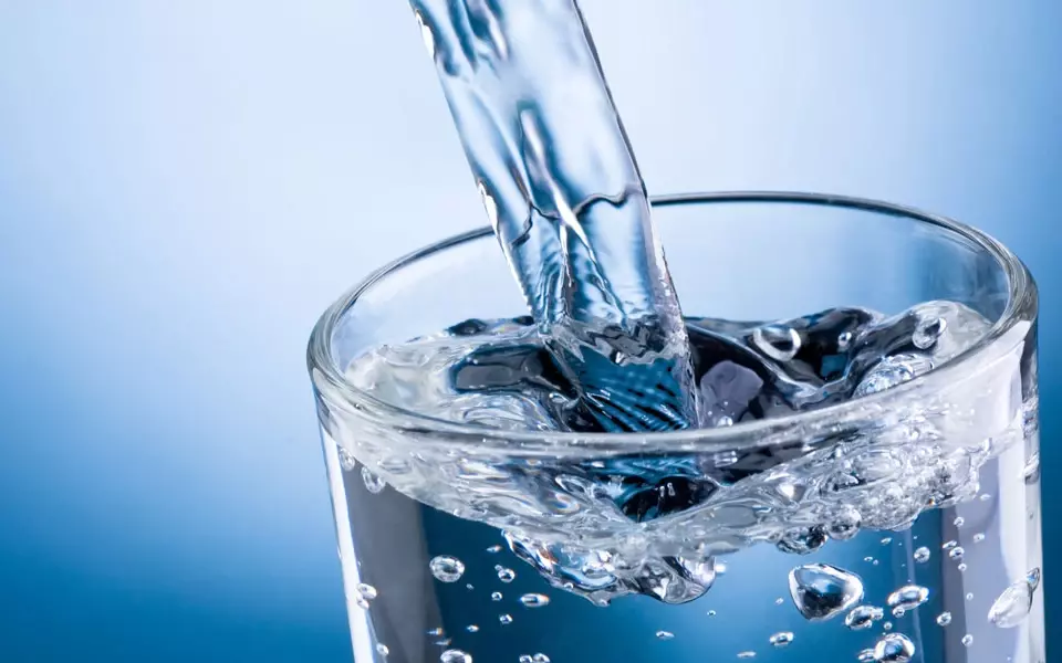 klares Wasser fließt in ein Glas