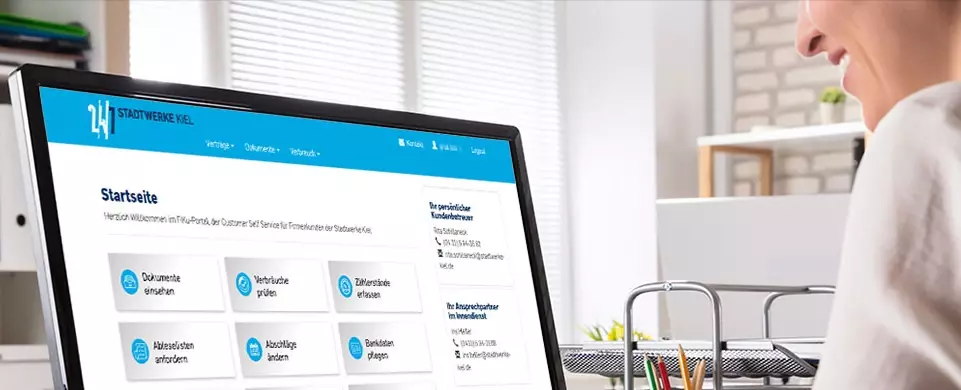 Frau im Büro blickt auf Monitor mit geöffneter Startseite FiKu-Portal