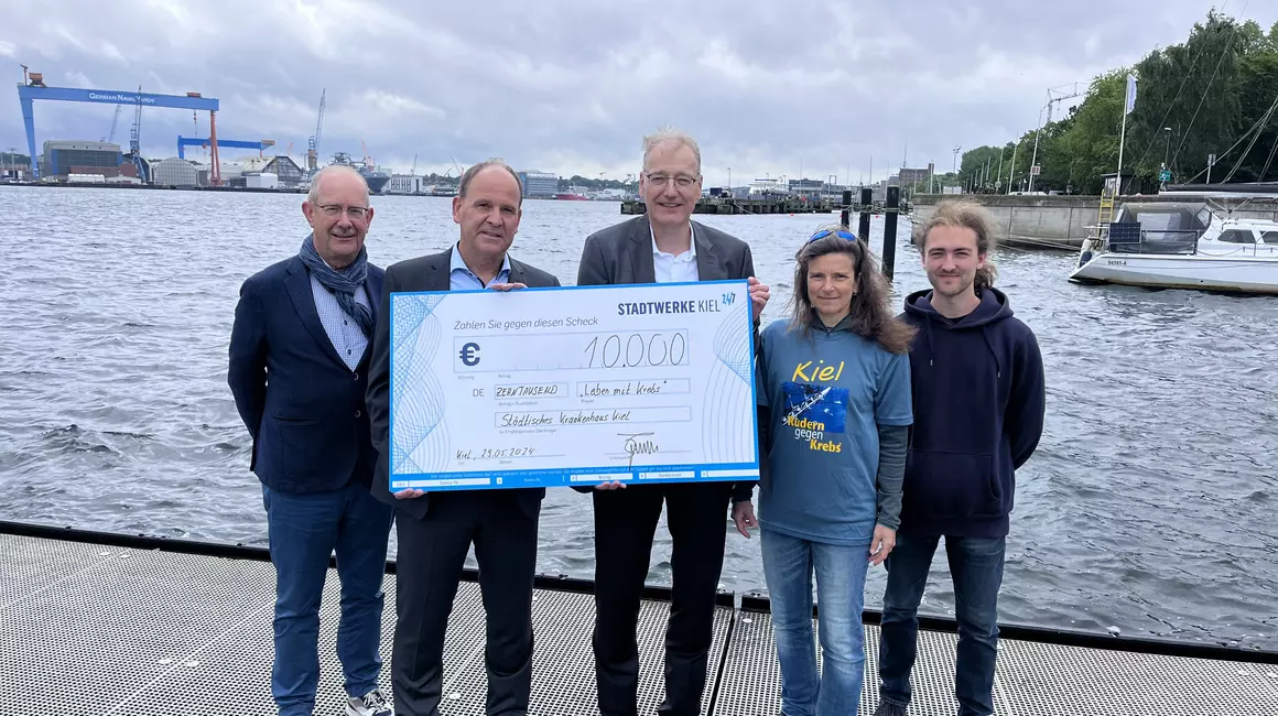 Dr. Jörg Teupen (mi.), Vorstand Technik und Personal der Stadtwerke Kiel, überreicht den symbolischen Scheck an Dr. Roland Ventzke (2.li.), Geschäftsführer Städtisches Krankenhaus Kiel, Claus Heinrich (li.), Schatzmeister EKRC; Astrid Schulz (2.re.), Leitung Sportprogramm Krebspatienten im SKK, und Mika Molder (re.), Verband Kieler Schülerrudervereine (VKSR). (Foto: Kieler Nachrichten)