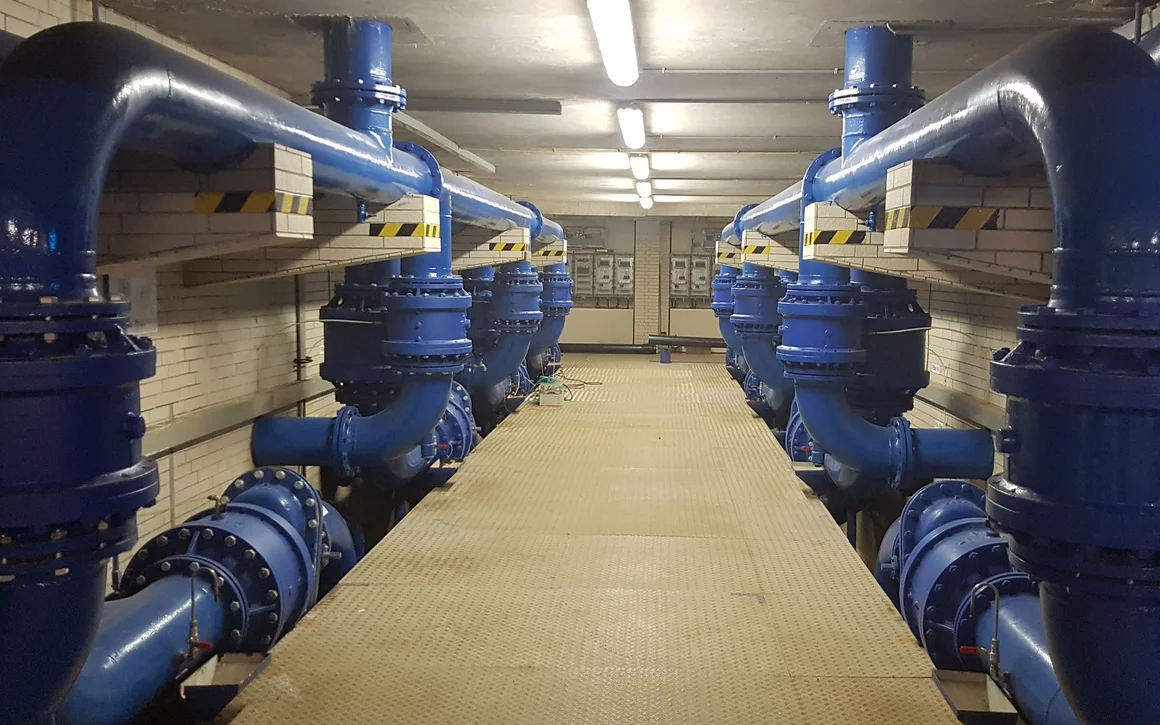 Riesige blau lackierte Rohre in fensterlosem Raum.