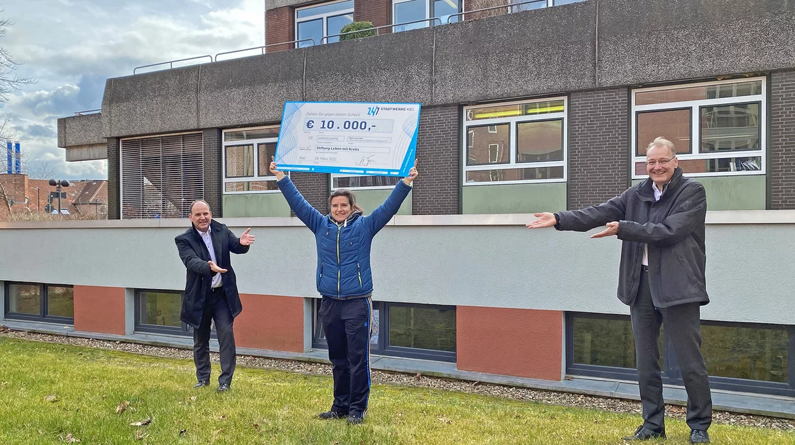 Astrid Schulz, Sporttherapeutin Städtisches Krankenhaus Kiel (SKK), nimmt gemeinsam mit SKK-Geschäftsführer Dr. Roland Ventzke (li.) die Spende von Dr. Jörg Teupen, Vorstand Technik und Personal Stadtwerke Kiel, entgegen.