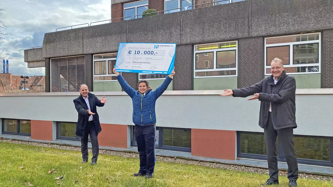 Astrid Schulz, Sporttherapeutin Städtisches Krankenhaus Kiel (SKK), nimmt gemeinsam mit SKK-Geschäftsführer Dr. Roland Ventzke (li.) die Spende von Dr. Jörg Teupen, Vorstand Technik und Personal Stadtwerke Kiel, entgegen.