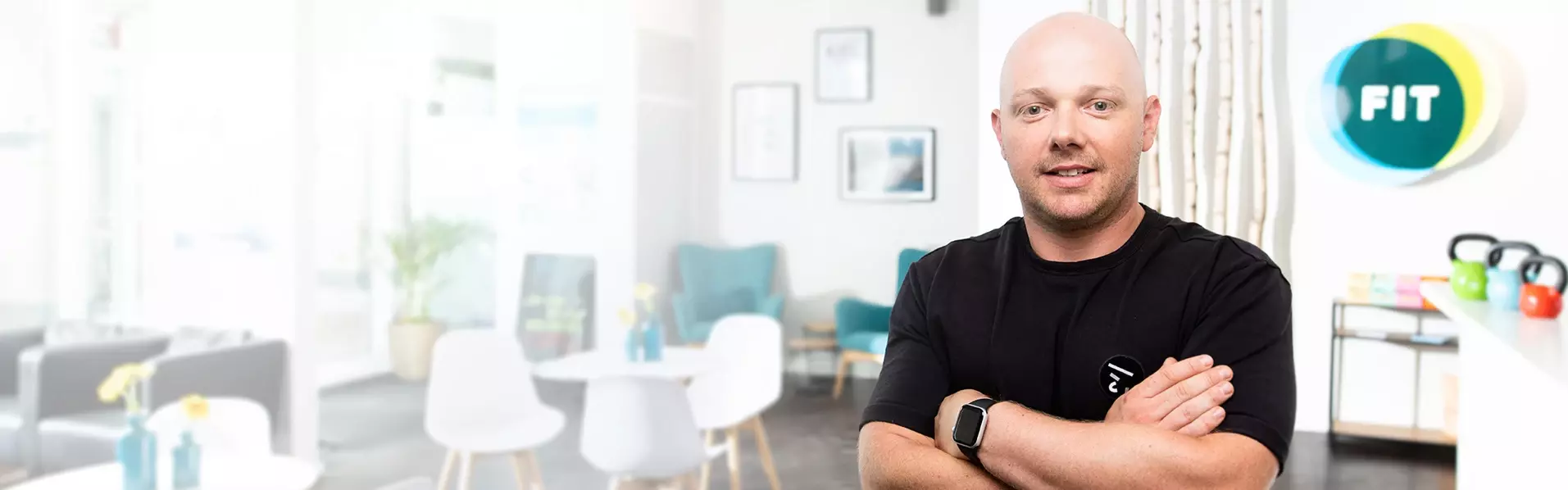 Lächelnder Mann vom Fitnessstudio FIT mit verschränkten Armen